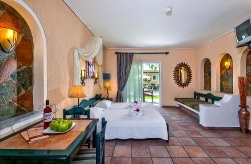 a hotel room with a bed and a table at Hotel Castle Suites in Platanias