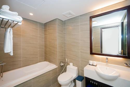 a bathroom with a toilet and a sink and a tub at D'Lioro Hotel & Resort in Ha Long