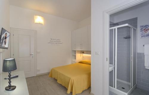 a bedroom with a yellow bed and a bathroom at City Hotel in Viareggio