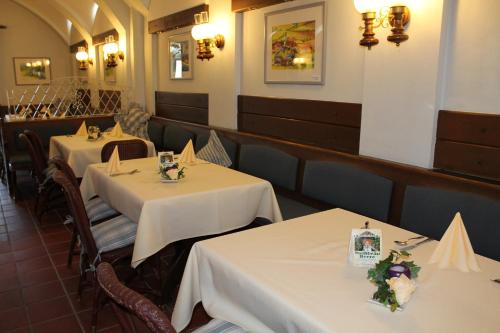 a restaurant with two tables with white tablecloths at Hotel Alter Weißbräu in Bad Birnbach