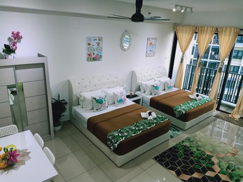 a bedroom with two beds and a table at D'Gunduls Homestay STUDIO by DGH I-CITY in Shah Alam