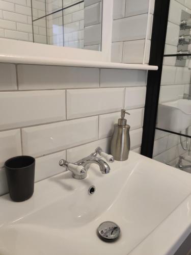 a white bathroom sink with a silver faucet at Anchors Away in Ayr
