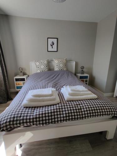 a bedroom with a bed with two towels on it at Anchors Away in Ayr