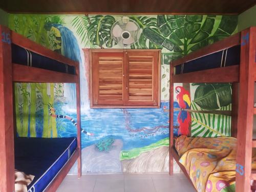 a room with two bunk beds and a mural at Ruamoko Hostel in Rivas