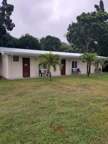 a building with palm trees in the yard at Monty's Riverside View Resort in San Antonio