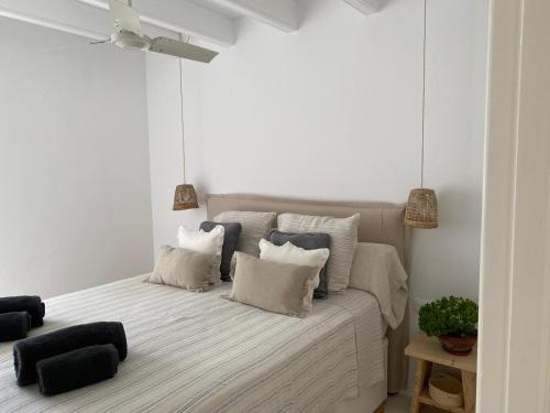 a white bedroom with a bed with pillows at Es Chalet in Sant Lluis