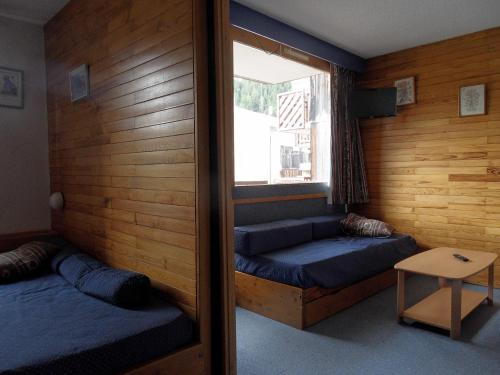 une chambre avec deux lits et une fenêtre dans l'établissement travelski home classic - Résidence Saint Jacques, à La Plagne