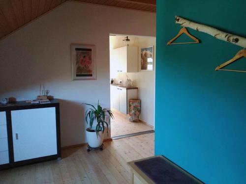 a living room with a plant and a kitchen at Ferienwohnung Susanne & Georg Guth in Beilngries