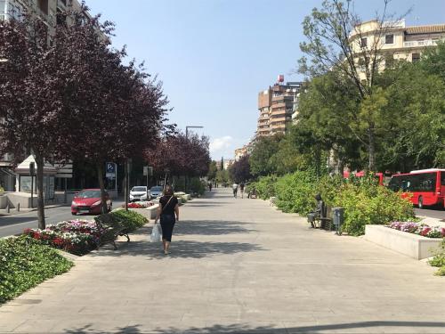 a woman walking down a sidewalk in a city at HNN GRANADA in Granada