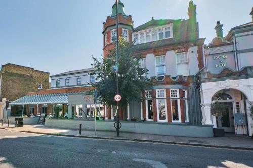 a building on a city street with a tree in front at Dog and Fox in London