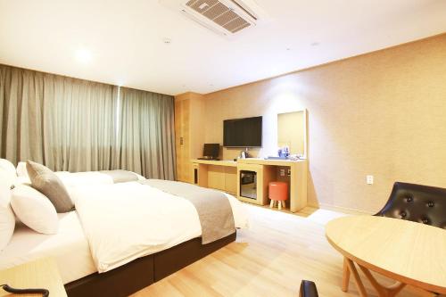 a hotel room with a large bed and a table at Paju Golden Hill in Paju