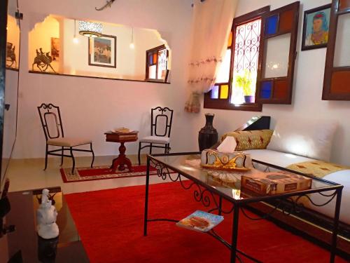sala de estar con sofá blanco y alfombra roja en DAR AZIZ en Marrakech