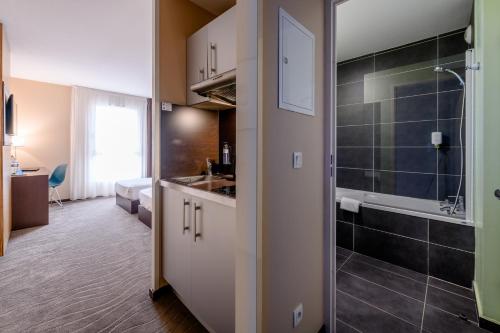 a bathroom with a sink and a shower in a room at Comfort Aparthotel Bordeaux Begles Arena in Bègles