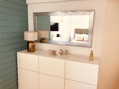 una camera da letto con specchio sopra un comò bianco; di Atlantic Luxury Apartment - Praia da Rocha a Portimão