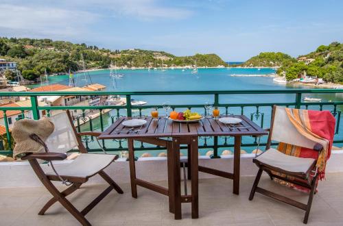 a table and chairs on a balcony with a view of the water at Lakka Seaview Apartments by Konnect in Lákka