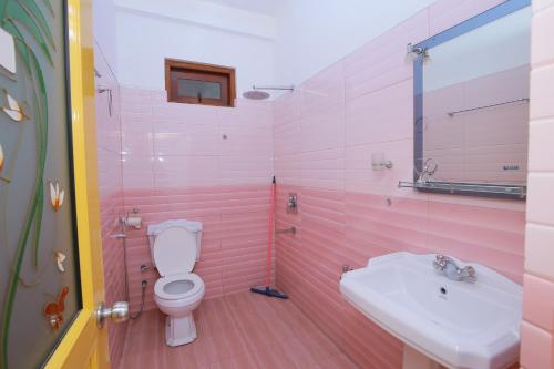 ein rosafarbenes Bad mit einem WC und einem Waschbecken in der Unterkunft Freedom Guest Inn Ella in Ella