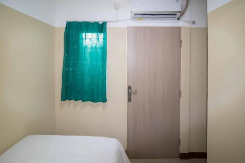 Miana Ancol Residence Mitra RedDoorz في جاكرتا: غرفة نوم بسرير ونافذة وباب