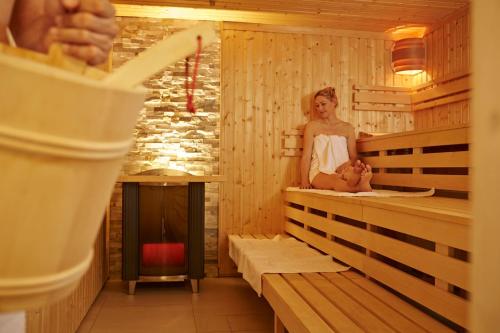 een vrouw die een baby vasthoudt in een sauna bij Landgasthof Hotel Hirsch in Loßburg