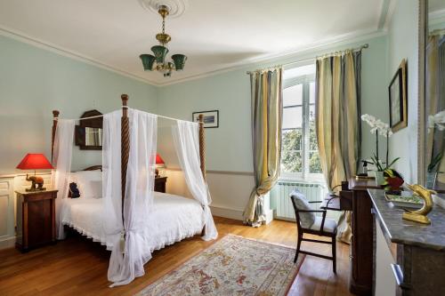 una camera con letto a baldacchino di Manoir de Bel Ébat a Crossac