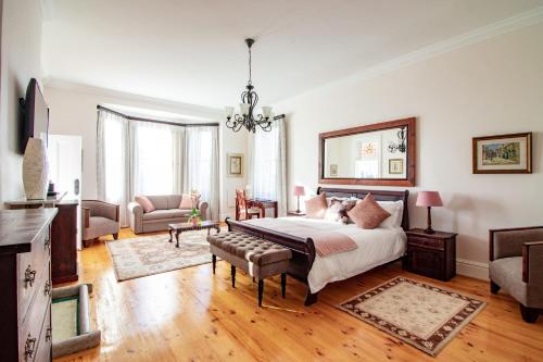 a bedroom with a bed and a living room at Carmichael House Boutique Hotel in Cape Town