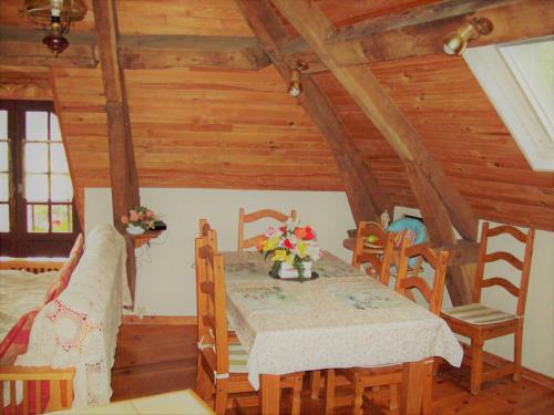 ein Esszimmer mit einem Tisch und Stühlen in einer Hütte in der Unterkunft Gîte du fourneau in La Forge-Neuve