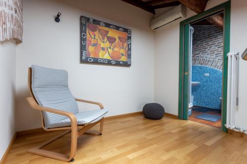 a chair in a room with a painting on the wall at Loft Mirano Tre (Alloggi alla Campana) in Mirano