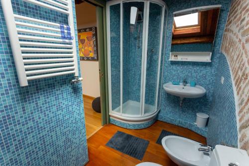een blauwe betegelde badkamer met een wastafel en een douche bij Loft Mirano Tre (Alloggi alla Campana) in Mirano