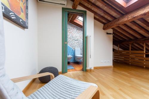 a living room with a couch and a door to a bathroom at Loft Mirano Tre (Alloggi alla Campana) in Mirano