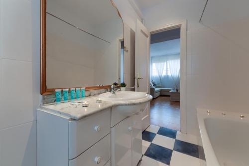 ein weißes Badezimmer mit einem Waschbecken und einer Badewanne in der Unterkunft Holidays2Malaga Soho Pasaje de Valencia in Málaga