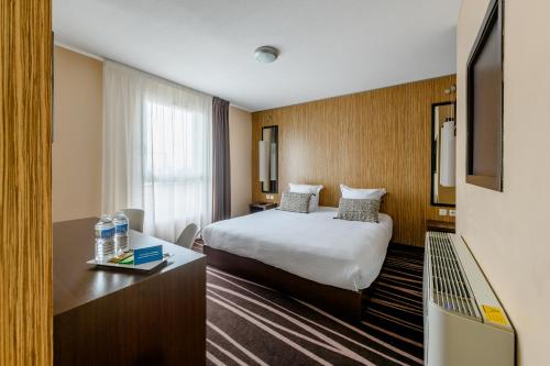 a hotel room with a bed and a television at Comfort Aparthotel Bordeaux Begles Arena in Bègles