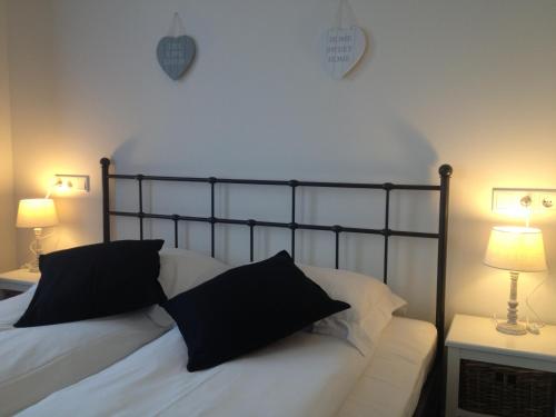 
a bed with a white comforter and pillows on it at Bed & Breakfast Villa Elisabeth in Domburg
