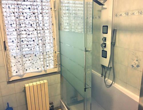 baño con ducha y puerta de cristal en rosso melograno, en Bareggio