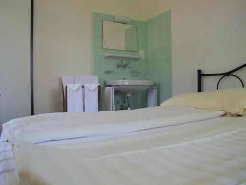 a bedroom with two beds and a sink and a mirror at Hotel Cafe Seeblick in Filzbach