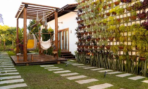 a garden with a hammock and a building at Vila Lua de Taipu - Taipu de Fora in Barra Grande
