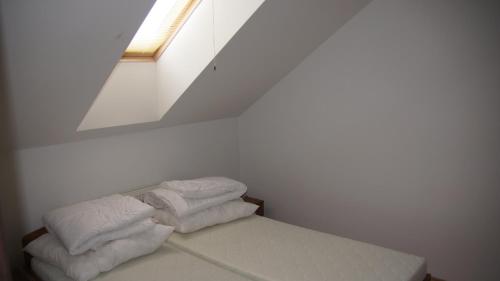 Una cama con dos toallas blancas en una habitación en Apartmany Podhajska, en Podhájska