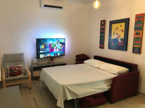 Schlafzimmer mit einem Bett und einem Flachbild-TV in der Unterkunft La Casa de la Higuerita in Fuengirola