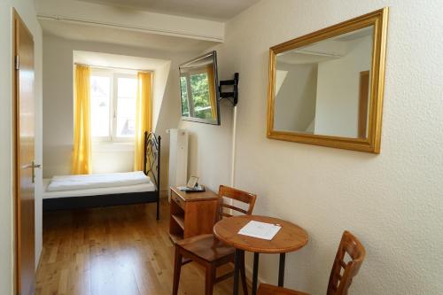 a room with a table and a mirror and a bed at Hotel Gasthaus Schützen in Freiburg im Breisgau