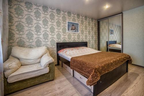 スモレンスクにあるApartment On Matrosova 16のベッドルーム1室(ベッド1台、椅子付)