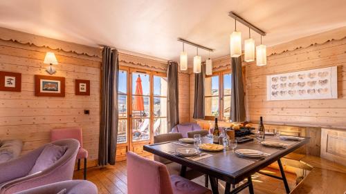 a dining room with a table and purple chairs at Madame Vacances Les Chalets de l'Altiport in L'Alpe-d'Huez