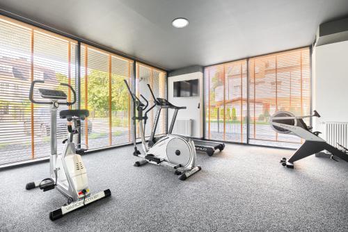 een fitnessruimte met loopbanden en hometrainers in een kamer bij Olimpijska 2 - City Apartments in Mielno