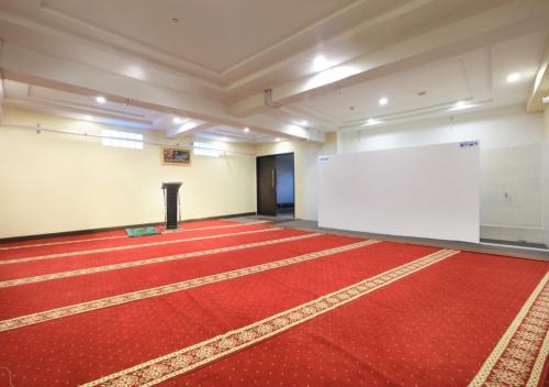 a large room with a red carpet and a white screen at Aston Kartika Grogol Hotel & Conference Center in Jakarta