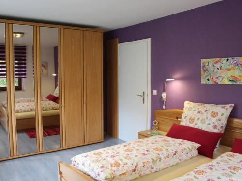 sypialnia z 2 łóżkami i lustrem w obiekcie Ferienwohnung Bienenherz w mieście Engelsbrand