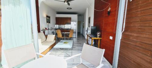 een woonkamer met witte stoelen en een keuken bij VV Canteras Ático "by henrypole home" in Las Palmas de Gran Canaria