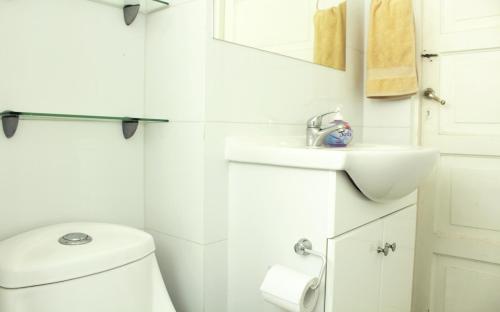 a white bathroom with a toilet and a sink at Acogedora Casa para familias y grupos in Santiago