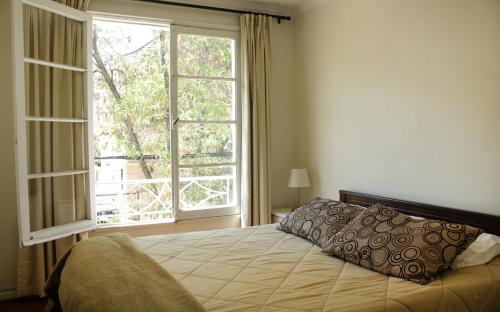 1 dormitorio con cama y ventana grande en Casa Familiar en Santiago