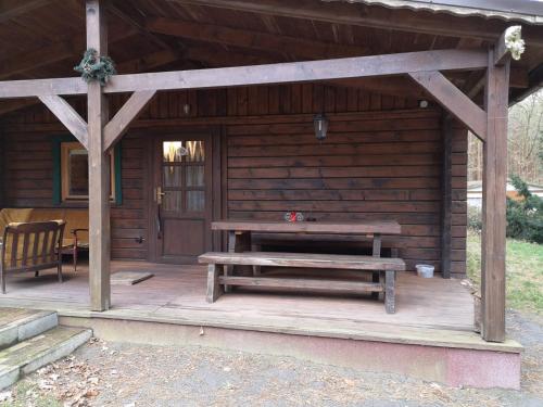 a wooden cabin with a picnic table and a bench at Ferienhaus Waldhütte Ferch in Schwielowsee