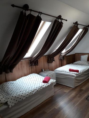 2 camas en una habitación con ventana en Cseppkő Panzió, en Abaliget