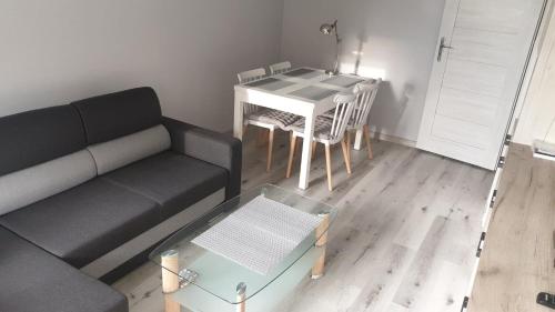 uma sala de estar com um sofá e uma mesa em Mieszkanie 2 pokojowe Pomorzany em Szczecin