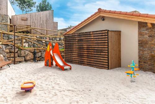 a playground with a slide in the sand at CieloAstur Complejo Turístico in Linares