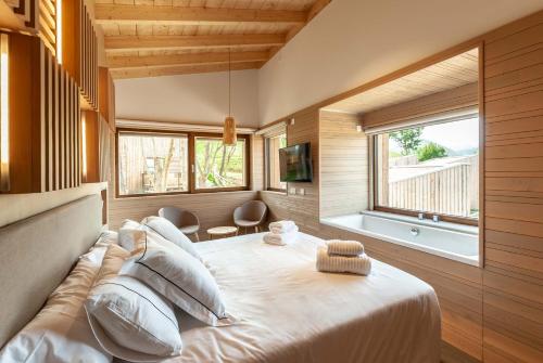 1 dormitorio con 1 cama grande y ventana grande en CieloAstur Complejo Turístico, en Linares